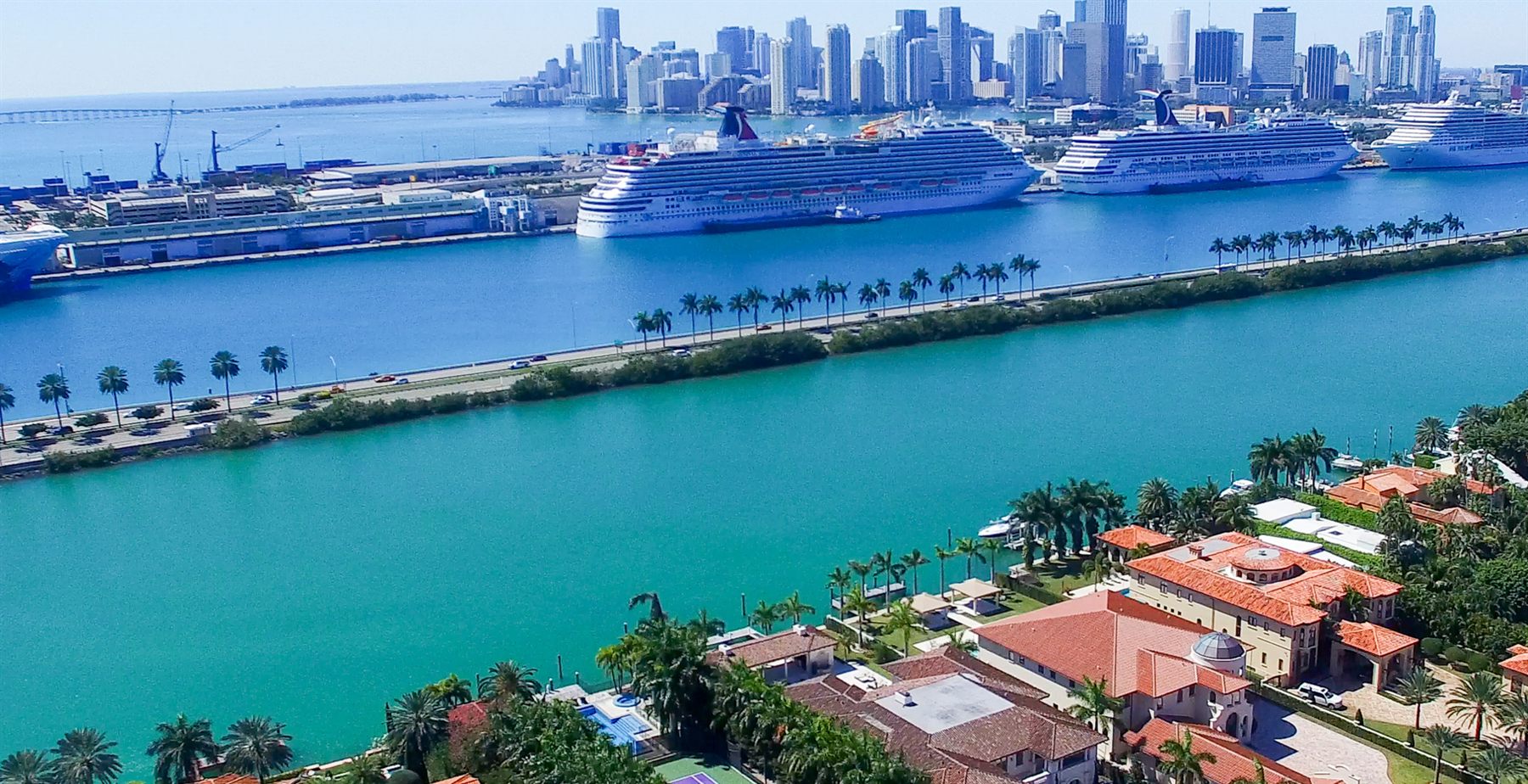 Aerial view of cruise ships docked at PortMiami below the downtown skyline